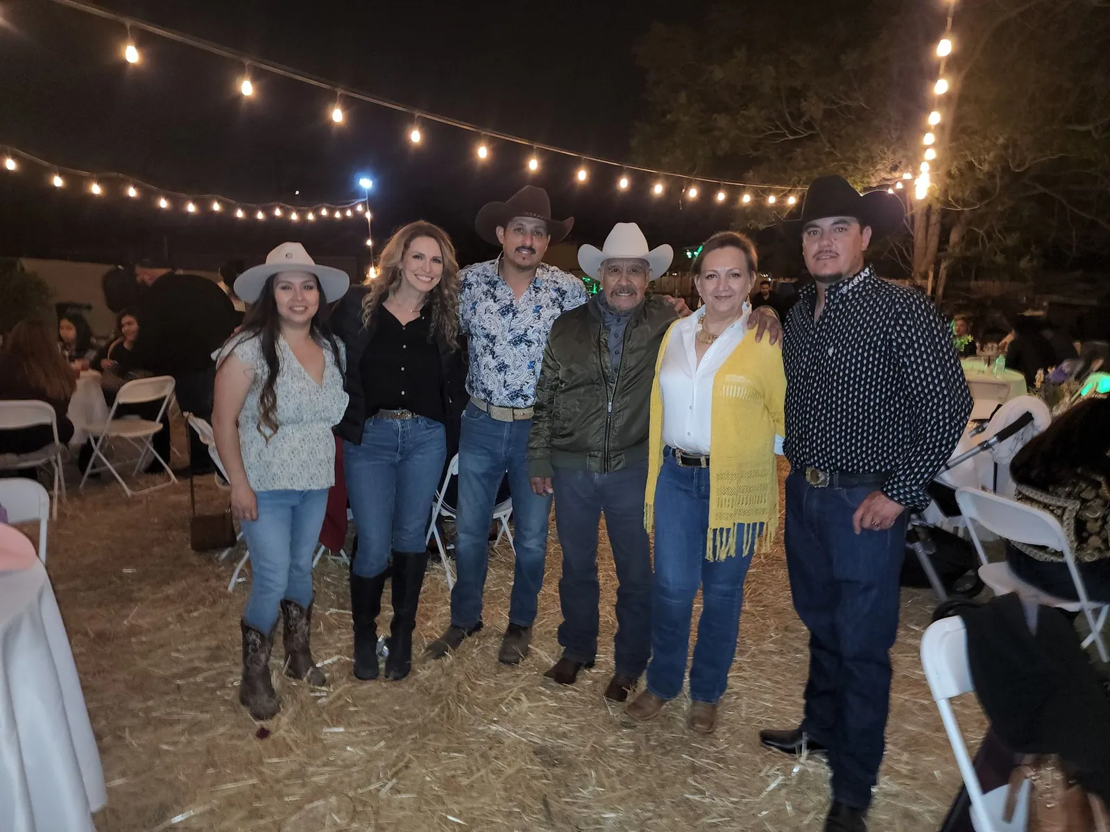 Family gathered beneath bistro lighting — Rancho Lagunas outdoor ranch event venue in Bloomington, California